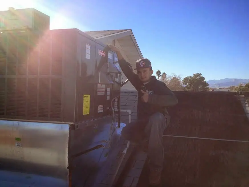 HVAC technician performing AC Tune-Up on a rooftop unit in Half Moon
